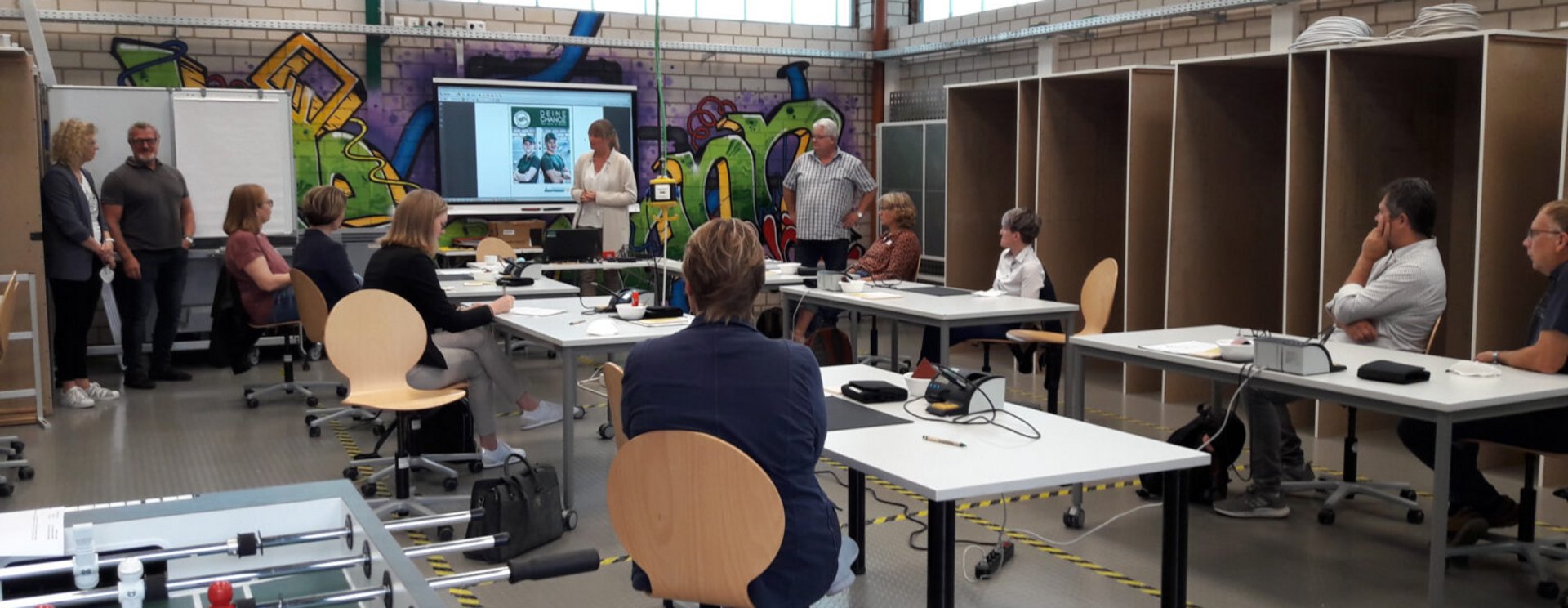 Mehrere Personen sitzen in einem Raum und nehmen an einem Workshop teil