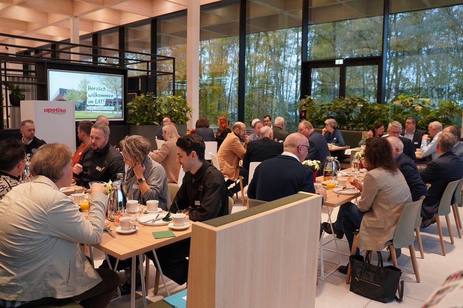 Ein großes Publikum sitzt in einer modernen Eventlocation.