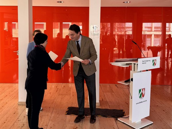 Regierungspräsident Andreas Bothe bei der Übergabe des Zuwendungsbescheids an Sonja Raiber (WESt). ©Bezirksregierung Münster