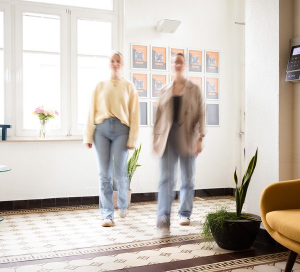 Zwei Personen laufen in ein Foyer.