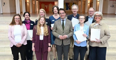 Sonja Raiber (2.v.l.) mit allen Projektbeteiligten und Regierungspräsident Andreas Bothe (6.v.l.). ©Bezirksregierung Münster